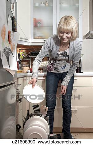 Woman putting dishes in dishwasher View Large Photo Image Stock Image - Woman putting dishes in dishwasher. Fotosearch