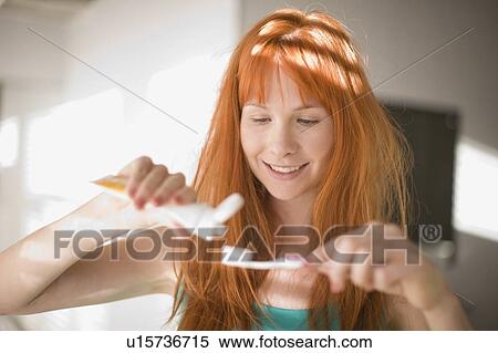 Woman putting toothpaste on toothbrush View Large Photo Image Stock Photography - Woman putting toothpaste on toothbrush. Fotosearch