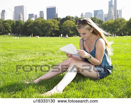 Woman reading a letter in central park View Large Photo Image Stock Image - Woman reading a letter in central park. Fotosearch