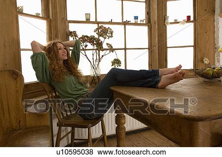 Woman relaxing at kitchen table View Large Photo Image Stock Photo - Woman relaxing at kitchen table. Fotosearch