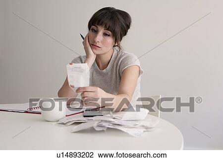 Stock Image - Woman reviewing receipts. Fotosearch