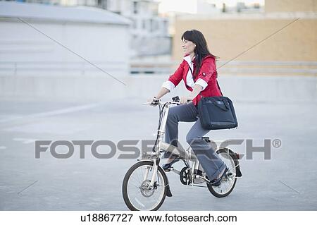 Woman riding a bicycle View Large Photo Image Stock Photo - Woman riding a bicycle. Fotosearch