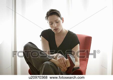 Stock Photo - woman rubbing her feet. Fotosearch