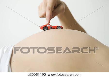 Woman running toy car on pregnant belly View Large Photo Image Stock Image - Woman running toy car on pregnant belly. Fotosearch