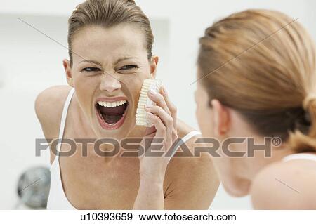Woman scrubbing her face View Large Photo Image Stock Photo - Woman scrubbing her face. Fotosearch