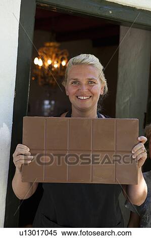 Stock Photography - Woman showing chocolatebar. Fotosearch