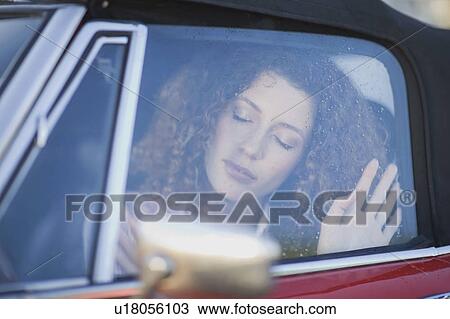 Stock Image - Woman sitting in a car. Fotosearch