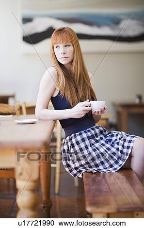 Stock Image - Woman sitting in a restaurant. Fotosearch