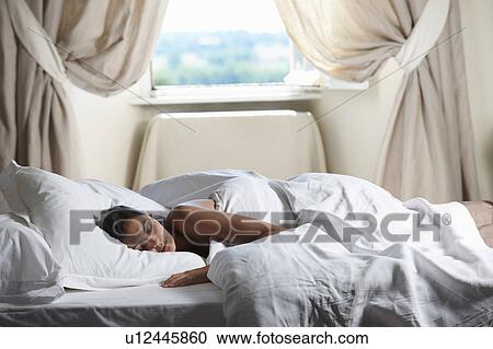 Woman sleeping in bed, by the window View Large Photo Image Stock Image - Woman sleeping in bed, by the window. Fotosearch