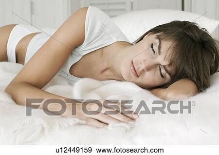Woman sleeping on a bed View Large Photo Image Stock Photo - Woman sleeping on a bed. Fotosearch
