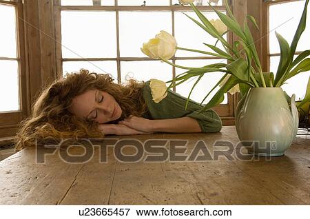 Stock Photo - Woman sleeping on kitchen table. Fotosearch