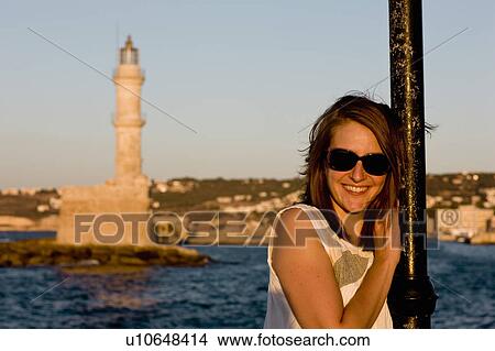 Picture - woman smiling at the camera in front of harbour. Fotosearch