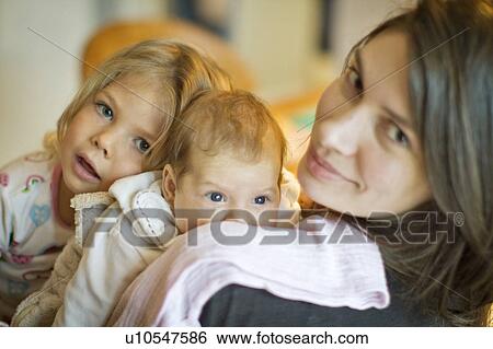 Stock Photograph - Woman smiling with daughters. Fotosearch