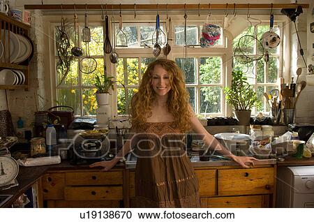 Woman standing in kitchen View Large Photo Image Stock Image - Woman standing in kitchen. Fotosearch