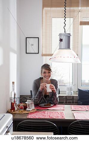 Stock Image - Woman stiing in kitchen. Fotosearch
