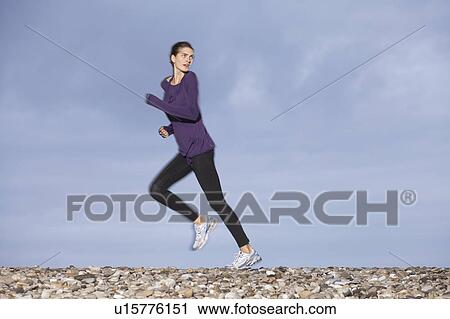 Stock Image - woman stretching on beach. Fotosearch