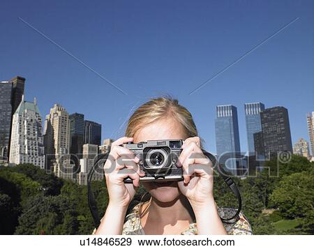 Woman taking pictures in central park View Large Photo Image Stock Photo - Woman taking pictures in central park. Fotosearch