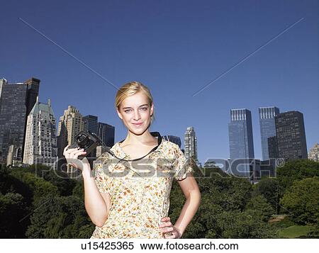 Stock Photography - Woman taking pictures in central park. Fotosearch