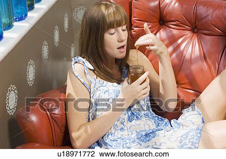 Stock Image - woman tasting honey. Fotosearch