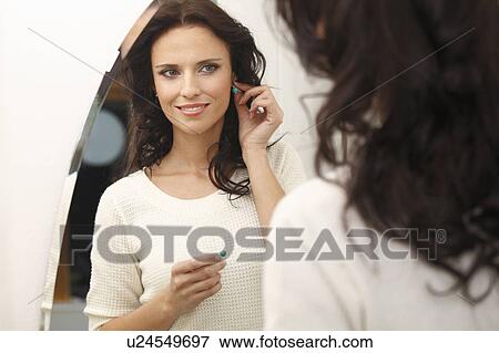 Stock Photo - woman trying on earrings. Fotosearch