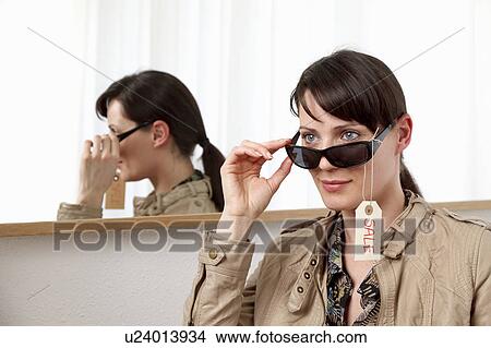 Picture - Woman trying on sunglasses. Fotosearch