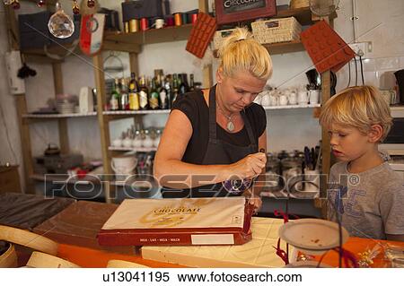 Stock Photography - Woman unpacking chocolatebar. Fotosearch