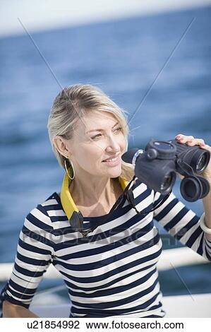 Woman using binoculars on boat View Large Photo Image Stock Image - Woman using binoculars on boat. Fotosearch