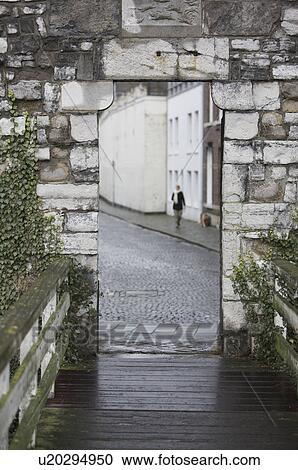 Stock Image - Woman walking through door frame. Fotosearch