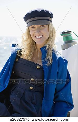 Stock Photography - Woman wearing jacket and hat on boat. Fotosearch