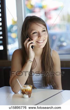 Stock Photograph - Woman with cellphone and icecream. Fotosearch