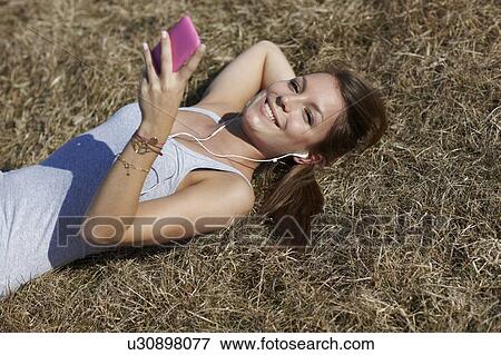 Woman with cellphone in meadow View Large Photo Image Stock Photo - Woman with cellphone in meadow. Fotosearch