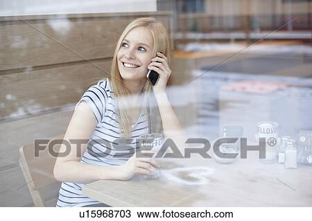 Stock Image - Woman with coffee and cellphone. Fotosearch