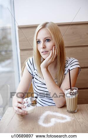 Stock Photo - Woman with coffee and sugar heart. Fotosearch