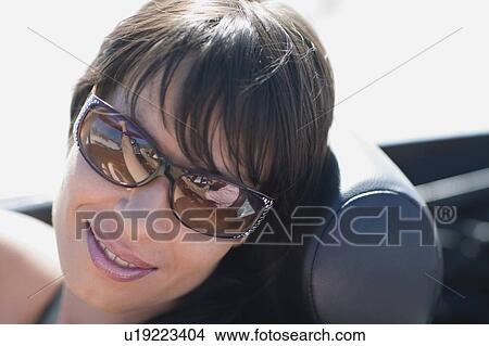 Picture - Woman with dark hair and big shades. Fotosearch