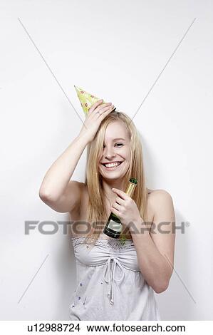 Picture - Woman with funny hat and bottle smiling. Fotosearch