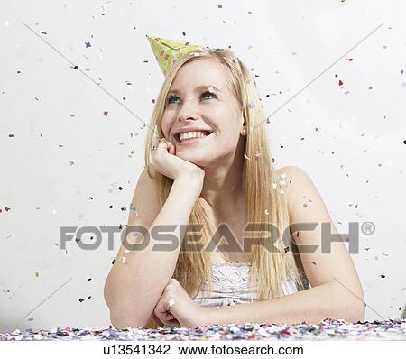 Stock Image - Woman with funny hat and confetti. Fotosearch