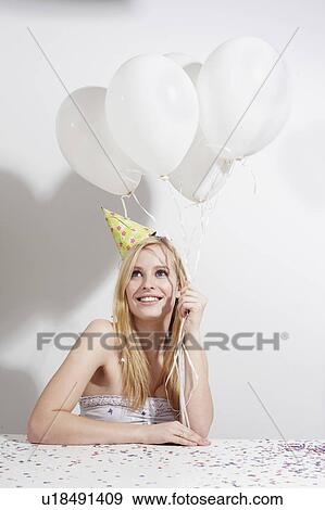 Stock Photo - Woman with funny hat and confetti. Fotosearch