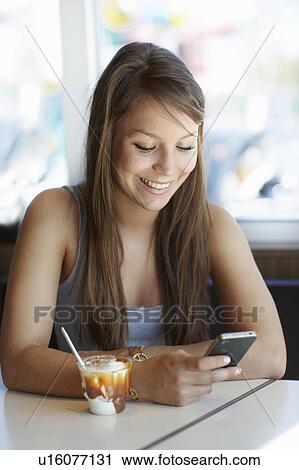 Stock Image - Woman with icecream and cellphone. Fotosearch