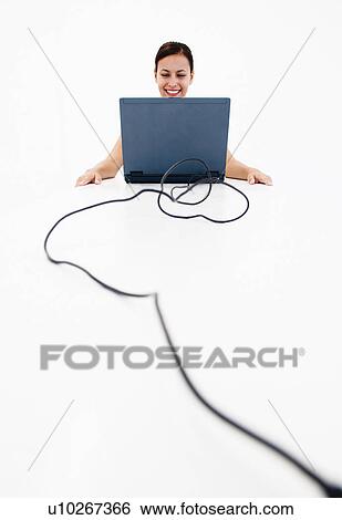 Stock Photograph - Woman with laptop on table. Fotosearch