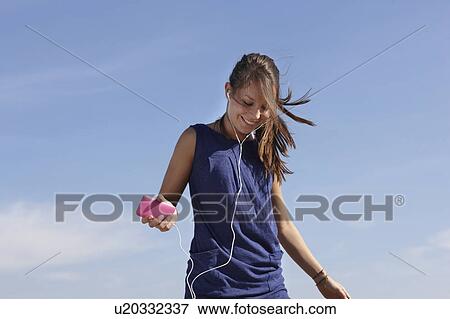 Woman with musicplayer jumping View Large Photo Image Stock Photo - Woman with musicplayer jumping. Fotosearch
