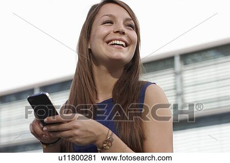Woman with smartphone smiling View Large Photo Image Stock Image - Woman with smartphone smiling. Fotosearch