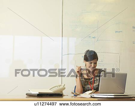 Woman working at desk View Large Photo Image Stock Photo - Woman working at desk. Fotosearch