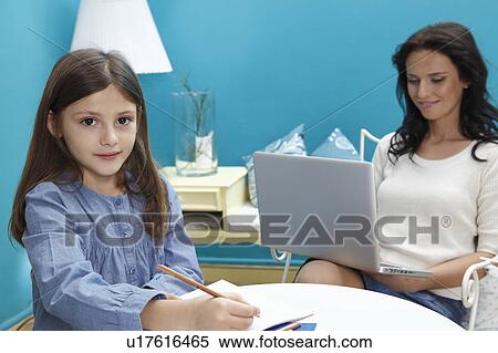 woman working on laptop with girl writing View Large Photo Image Stock Photography - woman working on laptop with girl writing. Fotosearch