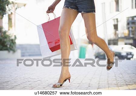 Womans legs with shopping bags running View Large Photo Image Stock Photo - Womans legs with shopping bags running. Fotosearch