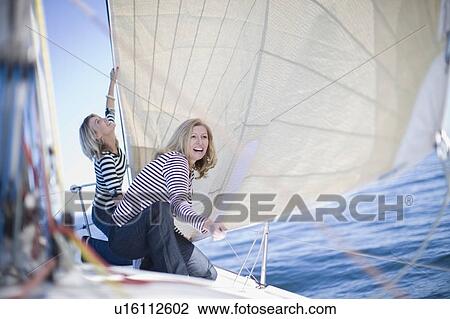 Women adjusting sail on boat View Large Photo Image Stock Image - Women adjusting sail on boat. Fotosearch