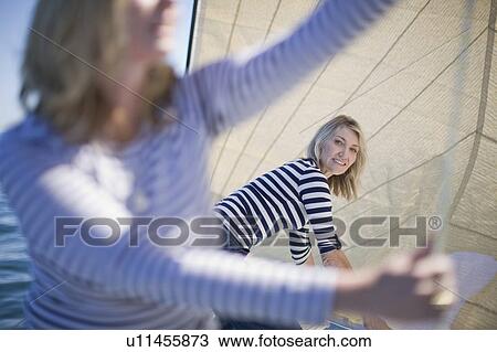 Women adjusting sails on boat View Large Photo Image Stock Image - Women adjusting sails on boat. Fotosearch
