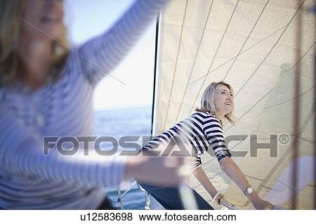 Women adjusting sails on boat View Large Photo Image Stock Photo - Women adjusting sails on boat. Fotosearch