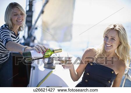 Stock Photo - Women drinking wine on boat. Fotosearch