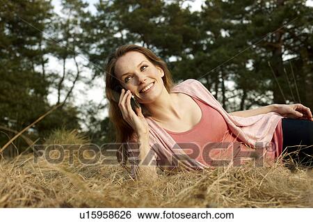 Stock Photograph - Women in Meadwow with Cellphone. Fotosearch