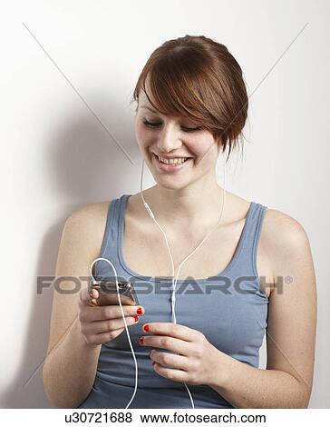 Stock Photo - Women smiling at mp3 player. Fotosearch